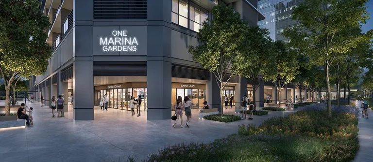 One Marina Gardens, artist&rsquo;s impression: the ground-floor shops under the tower at dusk, a tree-lined walk along the frontage with the One Marina Gardens name above